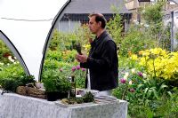 Chef demonstrating how to cook with herbs in a community garden 