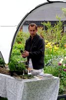 Chef demonstrating how to cook with herbs in a community garden