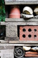 Insect habitat created with pallets, bricks, pots, stones, bark and piping for insects such as ladybirds, bees and lacewings to hibernate over winter