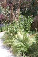 Willow structures in borders in wildlife garden. 'It's Only Natural' - Silver Gilt Medal Winner - RHS Hampton Court Flower Show 2010 