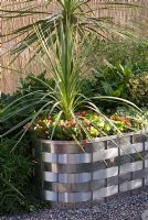 Stainless steel basket weaved container with Cordyline and Impatiens. 'Out of this World' - Bronze Medal Winner -  RHS Hampton Court Flower Show 2010
