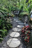 Circular stepping stones on gravel path. 'Out of this World' - Bronze Medal Winner - RHS Hampton Court Flower Show 2010
 