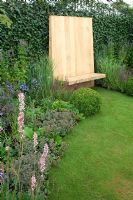 Wooden seat next to border with clipped Buxus balls - 'The Combat Stress Therapeutic Garden', Silver medal winner, RHS Hampton Court Flower Show 2010 
 