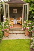 Summerhouse with roses 'Christopher Marlowe' in large terracotta pots - High Trees, Longton Stoke-on-Trent, Staffordshire, NGS