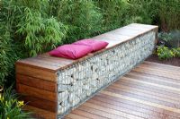 Bench made from wood and gabions backed by Fargesia murielae - Bamboo hedge