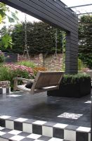 Wall as separation with hanging bench, black and white tiles on the terrace - Hobrede, Holland