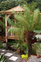 Wooden summerhouse and tropical planting. Colonial Chic and Bajan Roots - RHS Tatton Park 2010