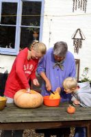 Leonie Woolhouse carving a pumpkin for Halloween with her grandchildren Tabitha and Arthur - The Old Sun House, Wymondham, Norfolk, NGS 