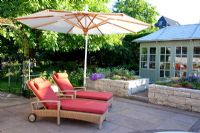 Paved terrace with loungers and parasol