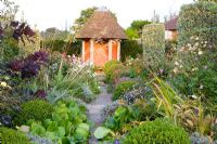 Country garden with view to gazebo, planting includes Stipa gigantea, Bergenia and clipped box 