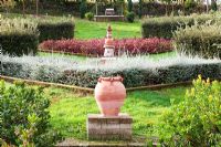 Lines of terracotta urns on plinths.The Field. Il Bosco Della Ragnaia, San Giovanni D'Asso, Tuscany, Italy, October. 
 