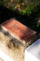 Inscription on brick. Il Bosco Della Ragnaia, San Giovanni D'Asso, Tuscany, Italy- The Field. October. 