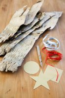 Making Christmas decorations from birch bark -Ssheets of bark with ribbons, scalpel and shape templates
