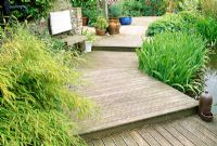 Shallow wooden steps beside pond in late Spring. Fovant Hut Garden, Wilts