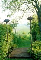Path down side of garden, with view framed by finial-topped posts. Late Spring, Fovant Hut Garden, Wilts. 