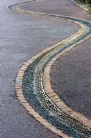 Drainage channel inlaid with black and white pebbles