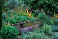 Eremurus shelford hybrid 'Cup Totem', Sedum 'Ruby Glow', Sedum 'Autumn Joy', mixed roses, Iris and Olive - Briar Dell 
