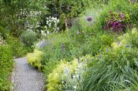 Stone path with Lychnis coronaria 'Alba', Nepeta x faassenii 'Walkers Low', Alchemilla mollis, Pennisetum, Geranium 'Rozanne', Dahlia 'Franz Kafka', Rosa 'Guirland d'Amour', Allium giganteum, Clematis 'Voluceau'