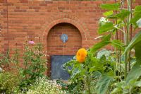 Decorative Water fountain built into the brick wall of a Potager