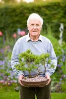 Man holding a Bonsai Pinus sylvestris - Scots Pine tree
