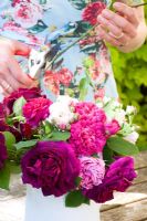 Woman trimming Rose stems for floral display on table