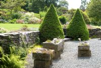 Large stone troughs planted with alpines and Picea glauca var. albertina 'Conica' at Holehird Gardens, Cumbria

