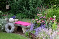 Stone bench with willow decorations next to border of  Hydrangea, Campanula poscharskyana and Lavandula - Lavender - Scheper Town Garden 