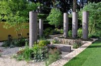 Concrete columns in sunken gravel garden.