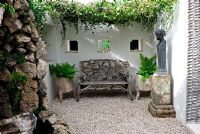 Garden bench made from tree roots in a courtyard garden