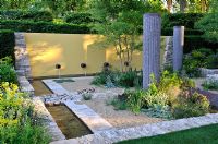 Water feature and columns in sunken gravel garden