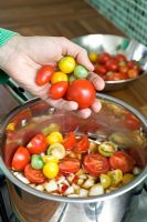 Making home-made mixed tomato chutney - putting ingredients into saucepan 