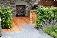 Log storage and dry stone walls with fireplace. Lavandula, Thymus and Fagus - Beech hedge. 'Inside Out'  garden - RHS Tatton Park Flower Show 2011 

