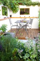 Table and chairs on modern decked terrace The Potential Feast Design - Raine Clarke-Wills Hampton court flower show 2011