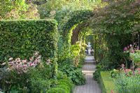 Path through formal garden with Fagus sylvatica - Beech hedging and statue focal point - Huys en Hof