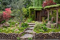 Best Artisan garden. Satoyama Life. designer Kazuyuki Ishihara sponsor Kazuyuki Ishihara Design Laboratory. Shed, water well, pebble edging stone path. Gold Medal winner.