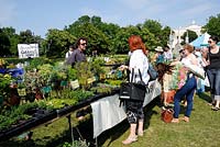 People around a stall selling herbs at Camden, now London Green Fair, Regent's Park, Central London, UK 