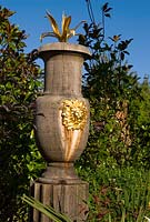 Turned oak urns decorated with gilded lions' heads and agaves are a feature of the upper level of the Collector Earl's Garden designed by Julian and Isabel Bannerman. 