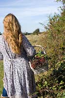 Woman gathering autumn berries in countryside