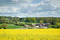 Views to open countryside and field of bright yellow rapeseed from the Dorothy Clive Garden NGS in late spring, Staffordshire