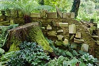 The 'Wall of Gifts' in the Stumpery consisting of various pieces of architectural stone, some of which were given to HRH The King, others he has collected. The Stumpery is based on a Victorian concept of growing ferns amongst tree stumps. Highgrove Garden, August, 2007. 