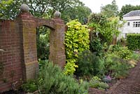 Brick archway in herb walled garden.