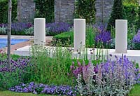 Chilstone upright cylinders on solid plinth placed alongside borders. 'The Italian Job' garden, Hampton Court Palace Flower Show 2012