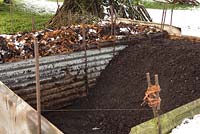 Large compost bin containing composted leaf mould 