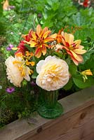 Mixed Dahlias, Roses and Crocosmia in vintage glass vase in the garden