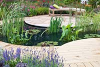 Central pond, surrounded by a decked path that leads to a seating area with sandstone paving and planting  that sweeps around the plot with Agapanthus, Cerinthe, Lavandula, Heuchera and Delphinium. 'A Taste of Ness' garden, RHS Tatton Flower Show 2012