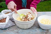 Step by step for creating hanging bird feeders out of teacups and yoghurt pots - stirring mixture 