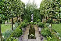 Formal garden with pleached Carpinus betulus allee, Buxus sempervirens balls, rill, Pyrus salicifolia 'Pendula' and beds of Dianthus and Bergenia. 