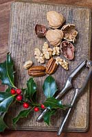 Nuts and nutcrackers on a table at home with Christmas holly