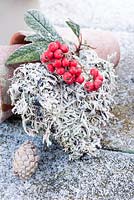 Frosty reindeer moss heart with cotoneaster berries and cones