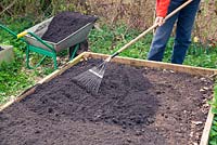 Using composted municipal waste to fill a raised bed.